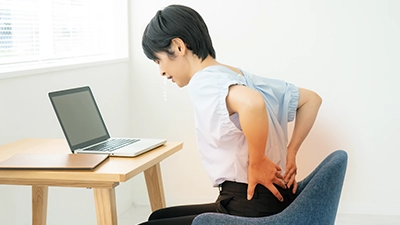 デスクワークで慢性腰痛に悩む女性